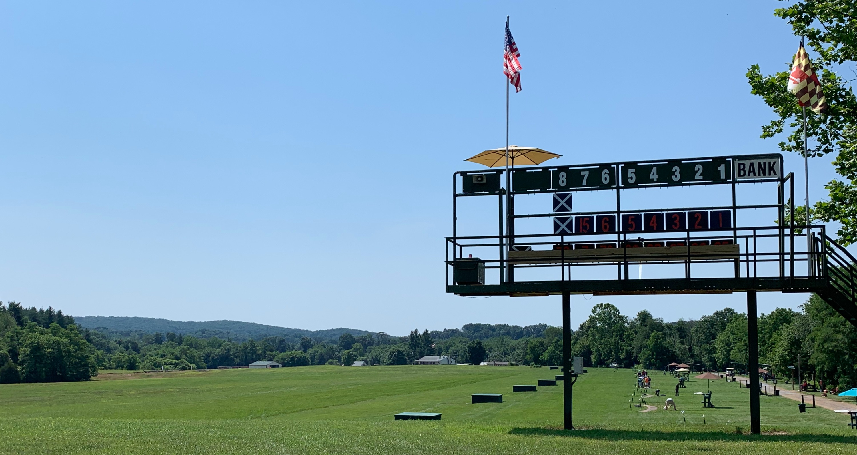 Trapshooters at the MSSA Homegrounds below the scoreboard and Maryland flag